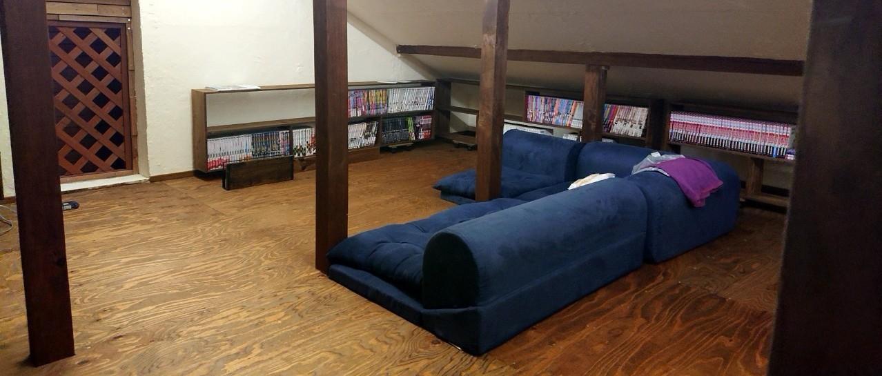 小屋裏に完成した漫画コーナー。DIYで造作した本棚とくつろぎのソファ。